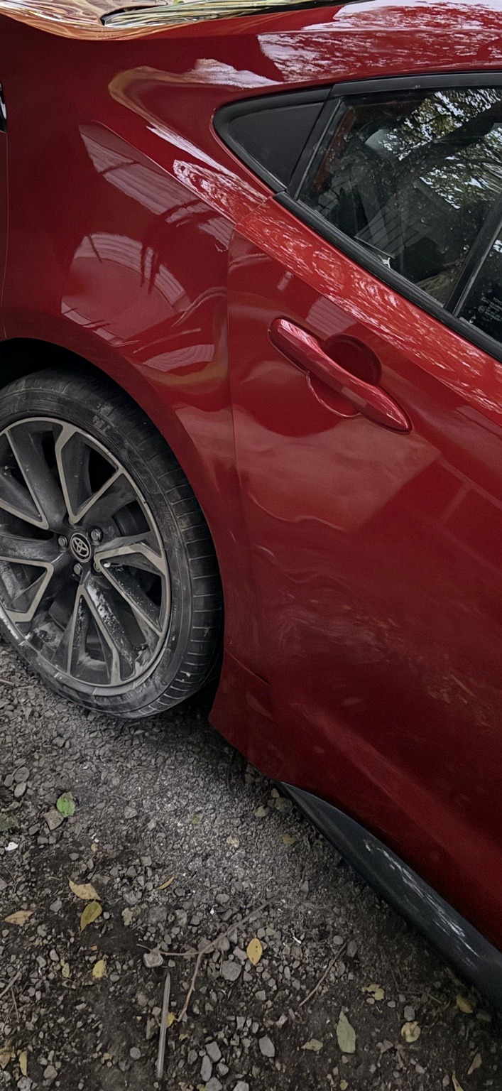 After paint and body repair on a red Toyota quarter panel